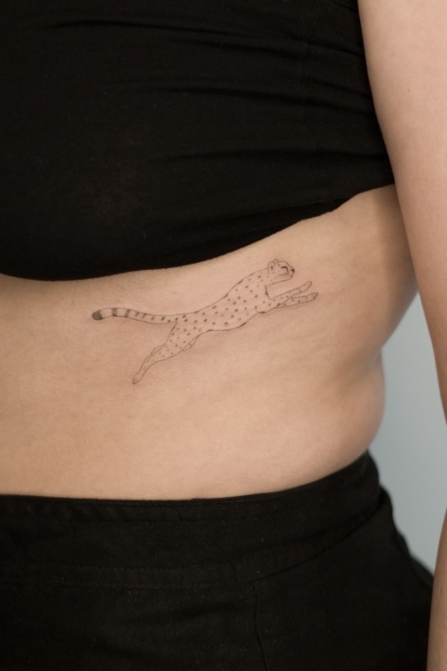 Close up to an belly with a running cheetah tattoo in minimal drawing style