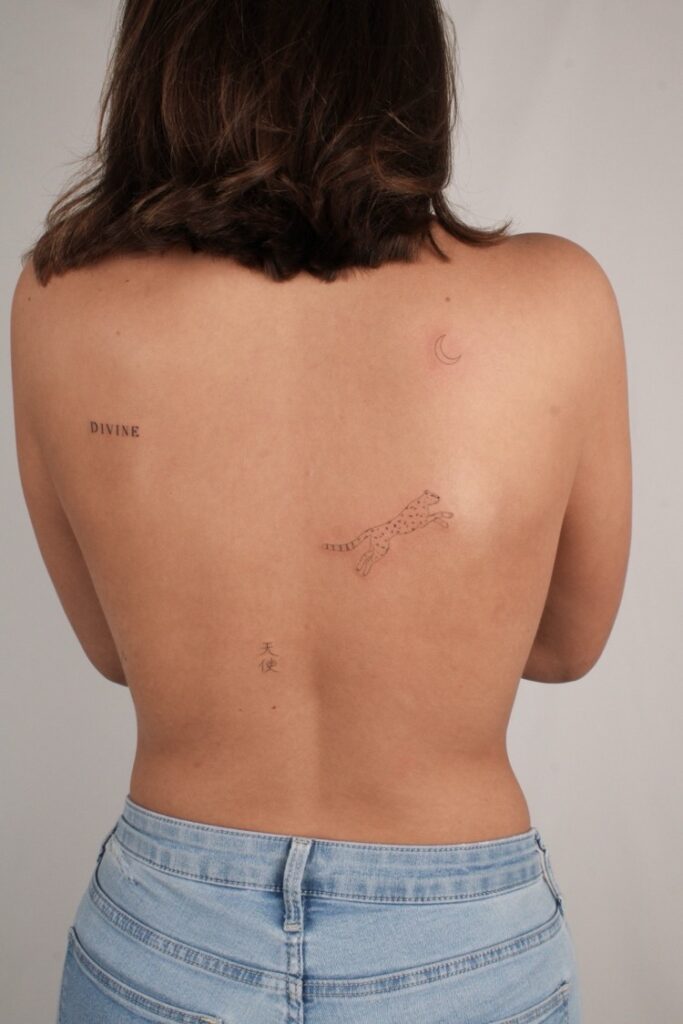 a woman's back with several small tattoos in minimal drawing style