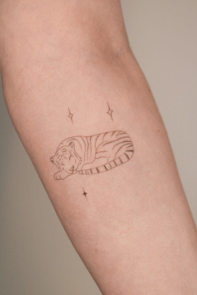 Close up to an arm with a tiger in minimal drawing style